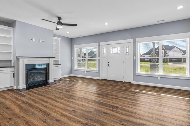 213 Lakeview Dr, Farmington, MO 63640 - unfurnished living room featuring baseboards, dark wood-style floors, a ceiling fan, a glass covered fireplace, and recessed lighting