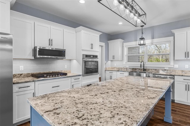 213 Lakeview Dr, Farmington, MO 63640 - kitchen with stainless steel appliances, a sink, a kitchen island, white cabinets, and backsplash