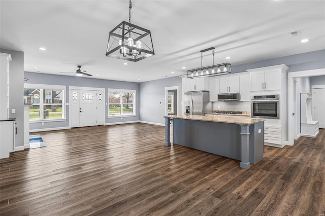 213 Lakeview Dr, Farmington, MO 63640 - kitchen featuring appliances with stainless steel finishes, open floor plan, a kitchen bar, white cabinets, and recessed lighting