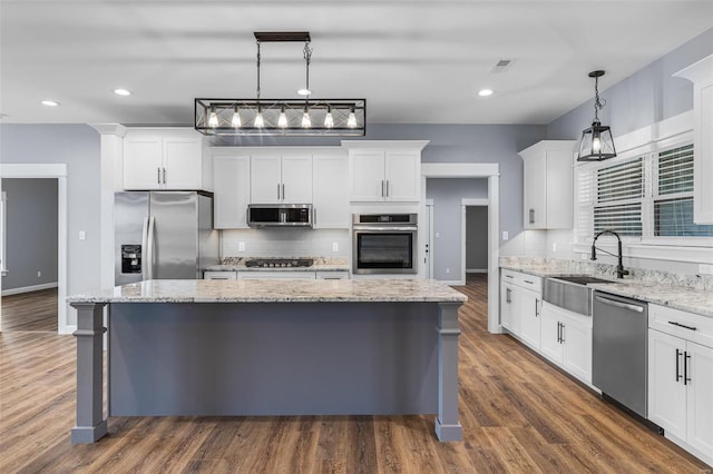 213 Lakeview Dr, Farmington, MO 63640 - kitchen featuring appliances with stainless steel finishes, a sink, a kitchen island, white cabinets, and decorative backsplash
