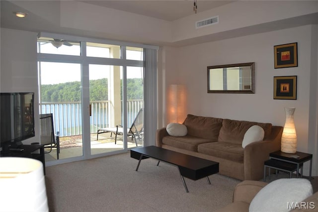 carpeted living room with a ceiling fan
