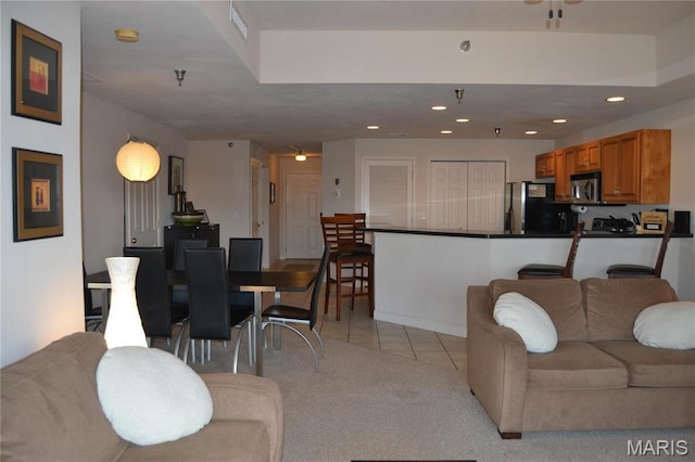 living room featuring light tile patterned floors, recessed lighting, and light carpet