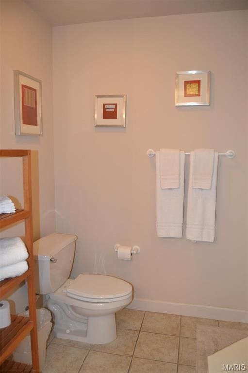 bathroom featuring toilet, baseboards, and tile patterned flooring