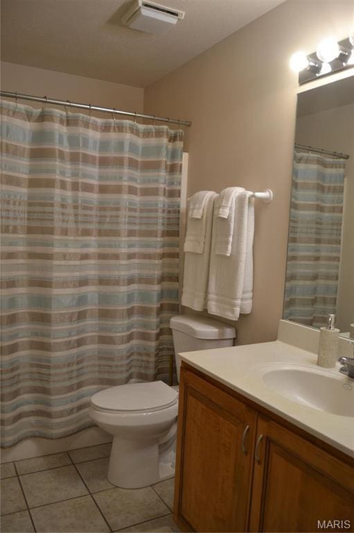 full bathroom with toilet, tile patterned floors, and vanity