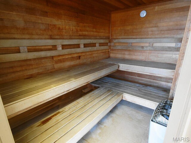 relaxing sauna featuring wooden walls