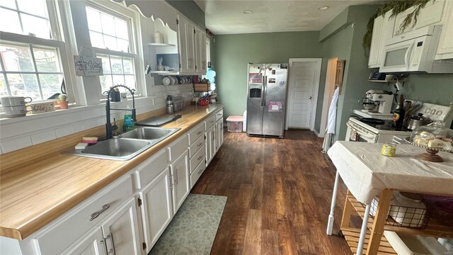 kitchen featuring white appliances, a sink, dark wood-type flooring, light countertops, and tasteful backsplash