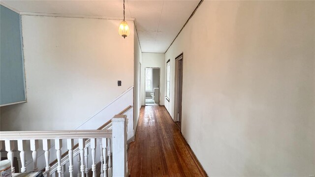 corridor with dark wood-type flooring and an upstairs landing