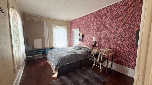 bedroom featuring crown molding, wood finished floors, and baseboards