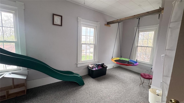 rec room featuring plenty of natural light, ornamental molding, baseboards, and carpet floors