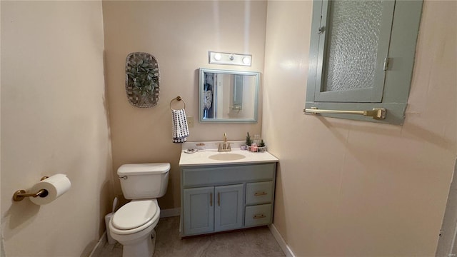 bathroom with toilet, vanity, tile patterned flooring, and baseboards