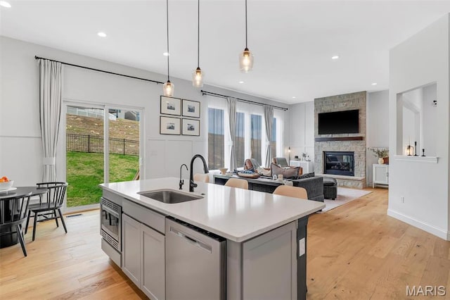 1154 Bloomfield Dr, Eureka, MO 63025 - kitchen featuring stainless steel appliances, a sink, gray cabinetry, a fireplace, and recessed lighting