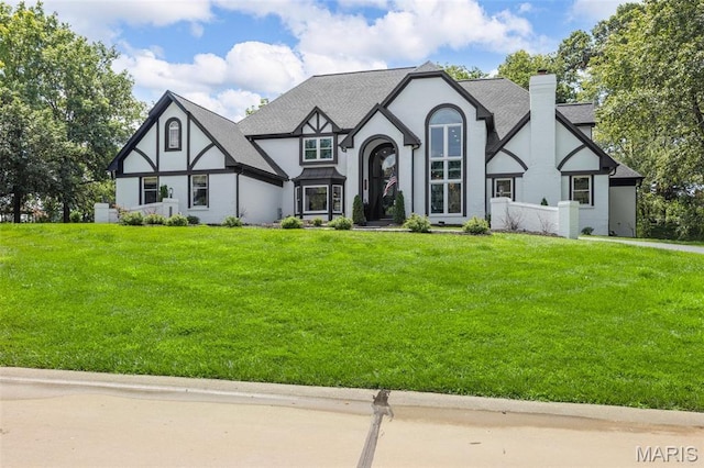 13516 Weston Park Dr, Saint Louis, MO 63131 - tudor-style house featuring a chimney, stucco siding, a front lawn, and roof with shingles