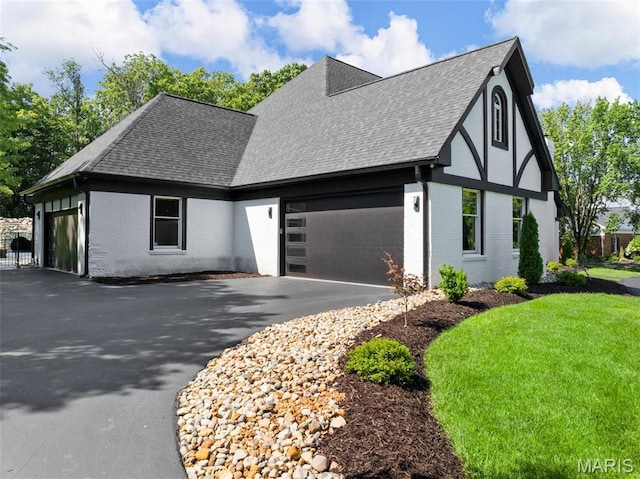 13516 Weston Park Dr, Saint Louis, MO 63131 - view of side of home featuring a shingled roof, brick siding, driveway, a garage, and a lawn