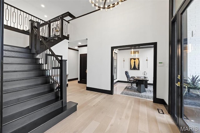 13516 Weston Park Dr, Saint Louis, MO 63131 - foyer featuring a high ceiling, light wood-type flooring, stairs, baseboards, and a chandelier