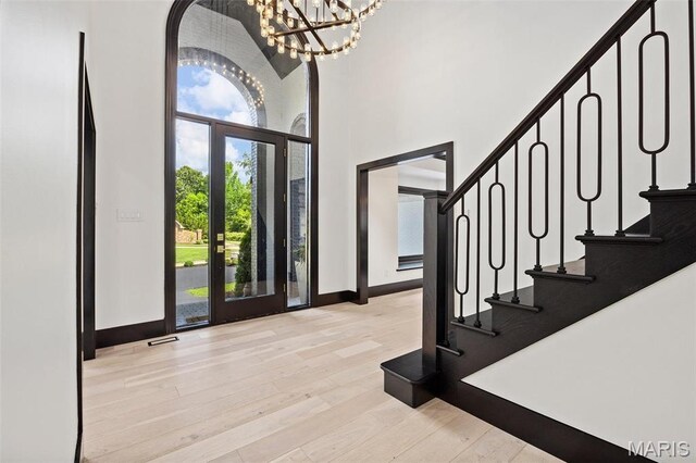 13516 Weston Park Dr, Saint Louis, MO 63131 - entryway featuring a high ceiling, wood finished floors, baseboards, a chandelier, and stairs