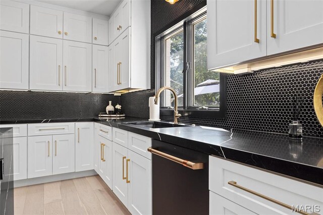 13516 Weston Park Dr, Saint Louis, MO 63131 - kitchen with dishwashing machine, a sink, white cabinetry, tasteful backsplash, and dark countertops