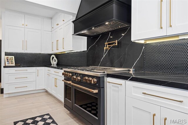 13516 Weston Park Dr, Saint Louis, MO 63131 - kitchen with range with two ovens, premium range hood, white cabinets, and dark countertops