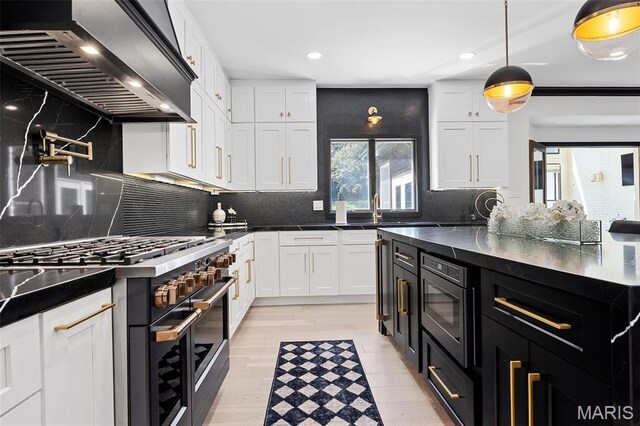 13516 Weston Park Dr, Saint Louis, MO 63131 - kitchen with double oven range, custom range hood, dark cabinetry, white cabinetry, and recessed lighting