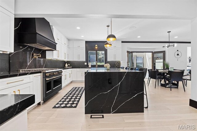 13516 Weston Park Dr, Saint Louis, MO 63131 - kitchen with range with two ovens, custom exhaust hood, recessed lighting, tasteful backsplash, and white cabinetry