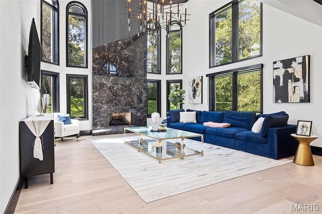 13516 Weston Park Dr, Saint Louis, MO 63131 - living room with a towering ceiling, wood finished floors, a chandelier, and a premium fireplace