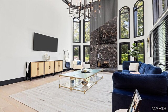 13516 Weston Park Dr, Saint Louis, MO 63131 - living area featuring a high ceiling, wood finished floors, plenty of natural light, a premium fireplace, and a chandelier