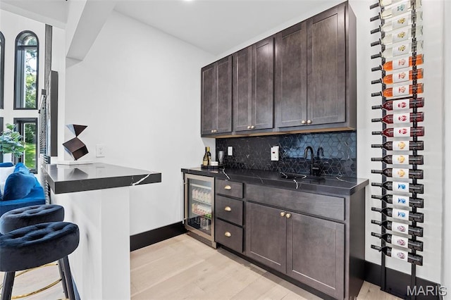 13516 Weston Park Dr, Saint Louis, MO 63131 - indoor wet bar with wine cooler, light wood-style flooring, backsplash, and baseboards
