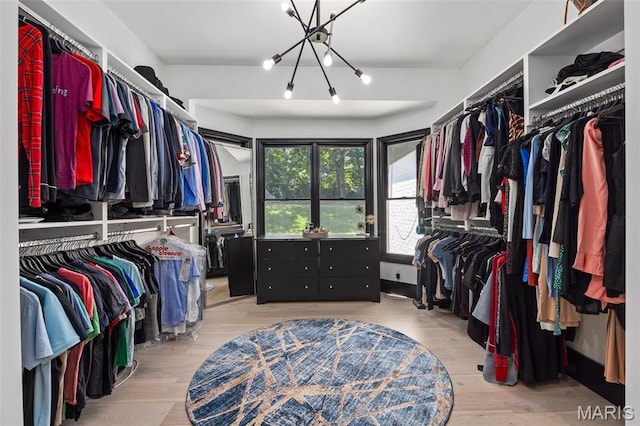13516 Weston Park Dr, Saint Louis, MO 63131 - walk in closet featuring wood finished floors and a chandelier