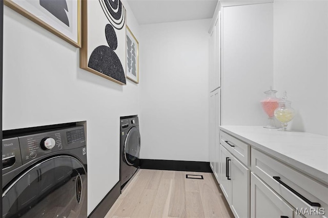 13516 Weston Park Dr, Saint Louis, MO 63131 - laundry room with washer and clothes dryer, cabinet space, and light wood-style flooring