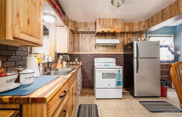 4434 County Road 4110, Salem, MO 65560 - kitchen featuring white range with electric stovetop, freestanding refrigerator, under cabinet range hood, brick wall, and a sink