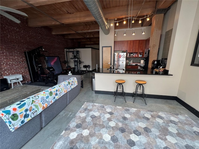 1113 Washington Ave Unit 510, Saint Louis, MO 63101 - living area featuring wood ceiling, brick wall, baseboards, beam ceiling, and concrete flooring