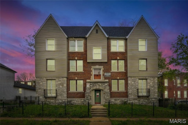 view of front of home featuring stone siding and a fenced front yard