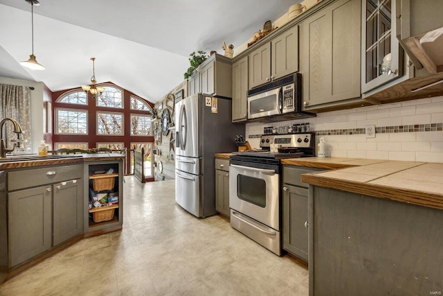 21933 Pike 215, Annada, MO 63330 - kitchen with stainless steel appliances, tasteful backsplash, a sink, lofted ceiling, and gray cabinetry