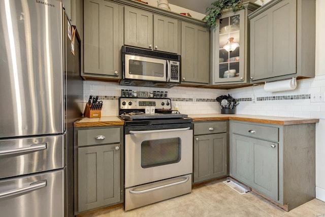 21933 Pike 215, Annada, MO 63330 - kitchen featuring appliances with stainless steel finishes, gray cabinetry, decorative backsplash, and glass insert cabinets