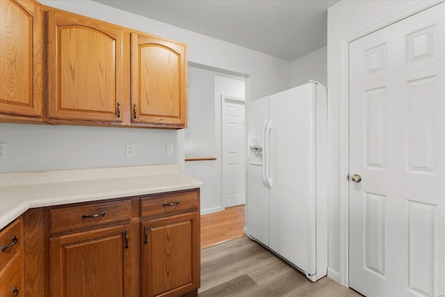1719 Ambrose Terrace Dr, Swansea, IL 62226 - kitchen with white fridge with ice dispenser, light wood-type flooring, light countertops, and brown cabinetry