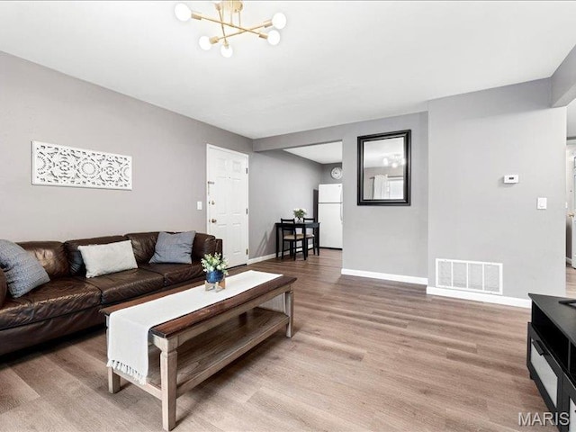1015 Adworth Dr Unit F, Saint Louis, MO 63125 - living area featuring light wood finished floors and a chandelier