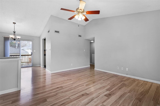 empty room featuring a chandelier, a ceiling fan, light wood finished floors, high vaulted ceiling, and baseboards