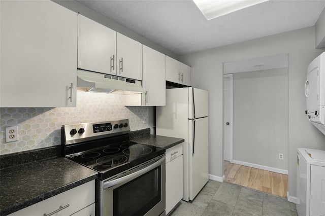 kitchen featuring under cabinet range hood, stainless steel electric range oven, freestanding refrigerator, decorative backsplash, and white cabinets