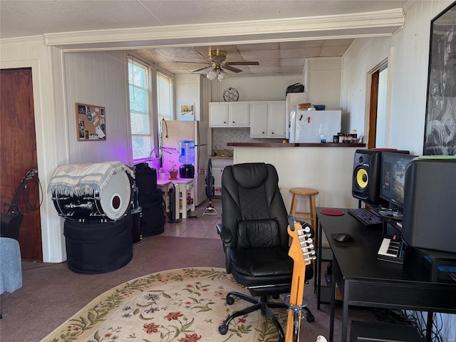 carpeted office with a ceiling fan