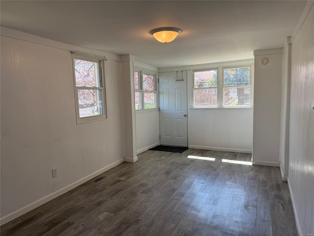 empty room featuring dark wood finished floors and baseboards