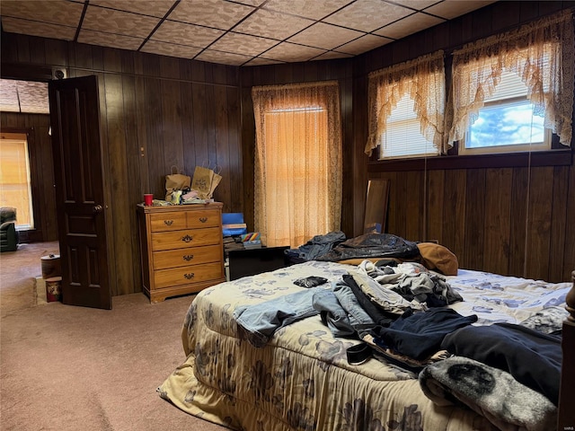 bedroom with light carpet and wood walls