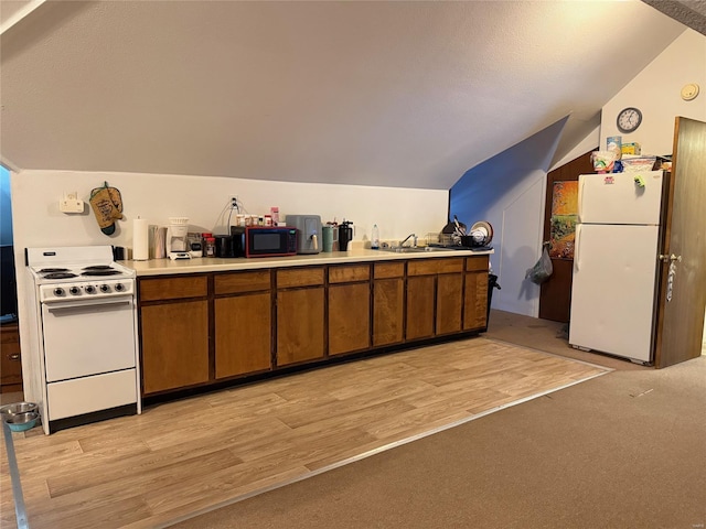 kitchen featuring white appliances, lofted ceiling, brown cabinetry, a sink, and light wood-style floors