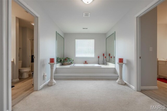 1005 Highland Estates Dr, Wentzville, MO 63385 - bathroom with a garden tub, toilet, vanity, and carpet flooring