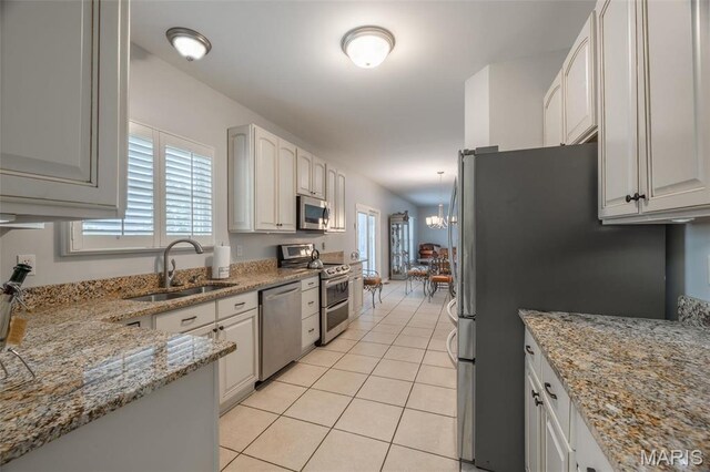 1005 Highland Estates Dr, Wentzville, MO 63385 - kitchen with stainless steel appliances, a sink, light tile patterned flooring, light stone counters, and a chandelier