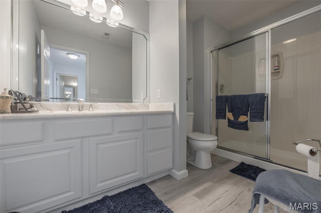 1005 Highland Estates Dr, Wentzville, MO 63385 - full bathroom featuring toilet, a stall shower, wood finished floors, and vanity