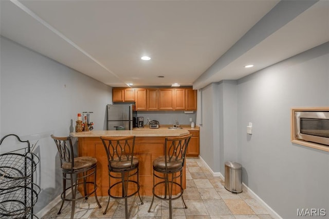1005 Highland Estates Dr, Wentzville, MO 63385 - kitchen featuring appliances with stainless steel finishes, a sink, a peninsula, recessed lighting, and light countertops