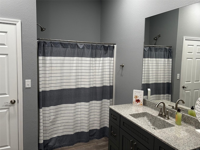 25371 Audrain Road 808, Mexico, MO 65265 - full bathroom featuring vanity, a shower with curtain, wood finished floors, and a textured wall
