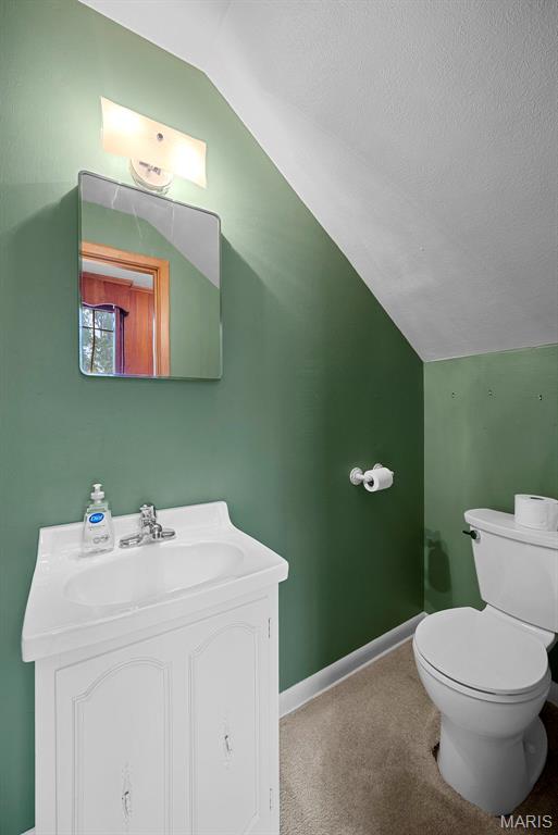 430 Cap Au Gris St, Troy, MO 63379 - half bath with vaulted ceiling, vanity, toilet, baseboards, and a textured ceiling