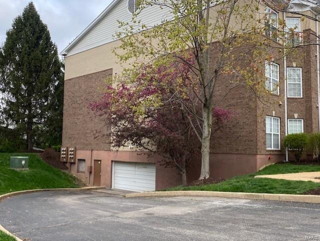 13115 Mill Crossing Ct Unit 106, Saint Louis, MO 63141 - view of building exterior with a garage, asphalt driveway, and central AC