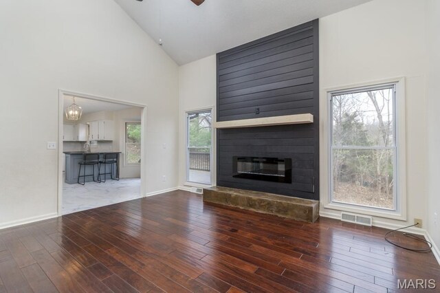 212 Tremont Dr, Waynesville, MO 65583 - unfurnished living room featuring high vaulted ceiling, hardwood / wood-style flooring, a large fireplace, ceiling fan, and baseboards