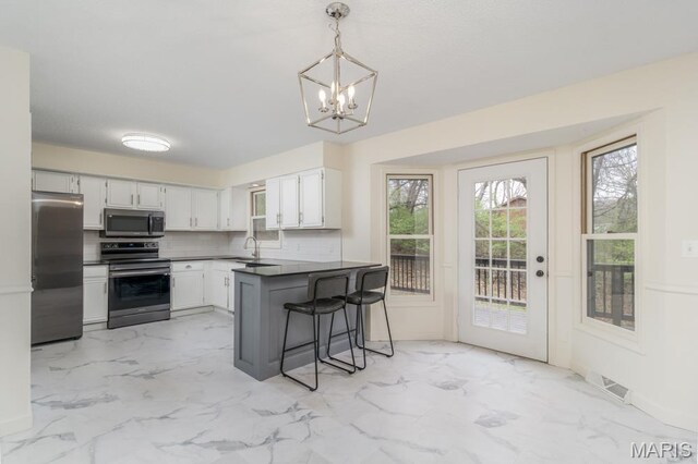 212 Tremont Dr, Waynesville, MO 65583 - kitchen featuring stainless steel appliances, a sink, light marble finish flooring, and a chandelier